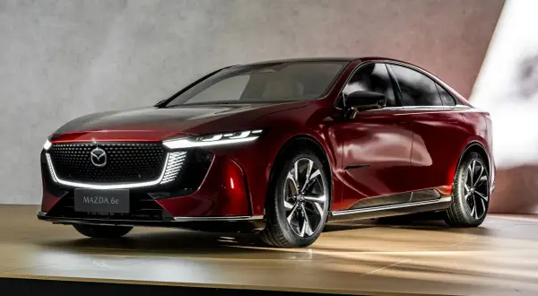 Elegancka, czerwona Mazda 6e 2025 z nowoczesnymi światłami LED i chromowanymi detalami.