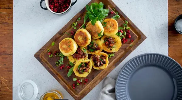 Kroppkakor recept: Gyllene kroppkakor fyllda med fläsk och toppade med färsk persilja, serverade med lingon och senap.