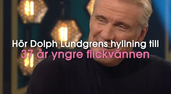 Dolph Lundgren, känd för sin kampsport, ler. Texten lyder: "Hör Dolph Lundgrens hyllning till 37 år yngre flickvännen".