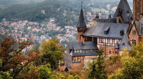 Blick auf Schloss Wernigerode mit der Stadt im Hintergrund. Entdecken Sie die **Geheimtipps Wernigerode** für Ihren nächsten Ausflug.