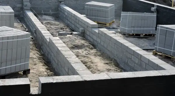 Budowa fundamentów z bloczków betonowych, przygotowanie pod izolację pionową fundamentów.
