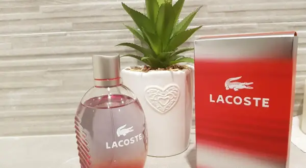 Perfumy męskie Lacoste Red 125ml w szklanej butelce obok czerwonego kartonika.