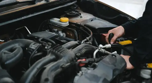 Mechanik pracuje przy silniku, sprawdzając, czy sucha miska olejowa jest szczelna.