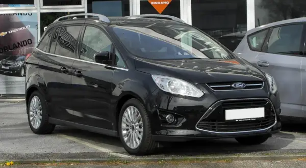 Czarny Ford C-Max na parkingu. Zastanawiasz się nad jego wymiarami? Ten rodzinny van oferuje przestronne wnętrze i praktyczne rozwiązania.