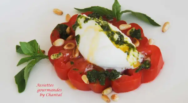Tomate burrata gastronomique, un délice estival avec pesto, pignons et basilic frais.