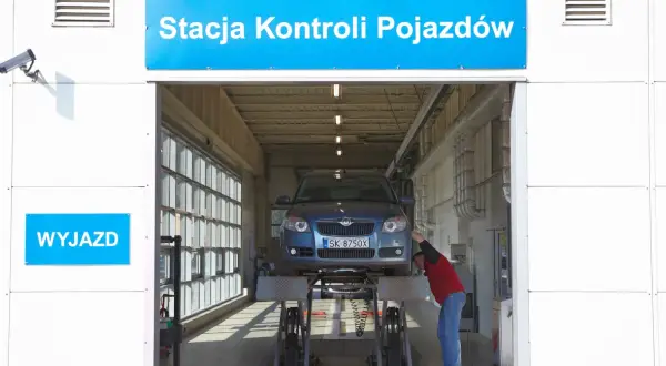 Pracownik sprawdza samochód na podnośniku. Dowiedz się, ile kosztuje przegląd samochodu w stacji kontroli pojazdów.