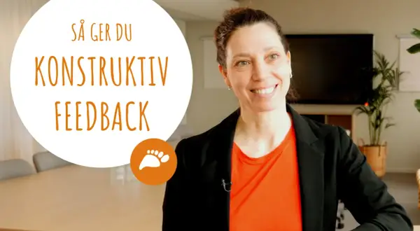 Kvinna ler och ger tips om hur man ger konstruktiv feedback.