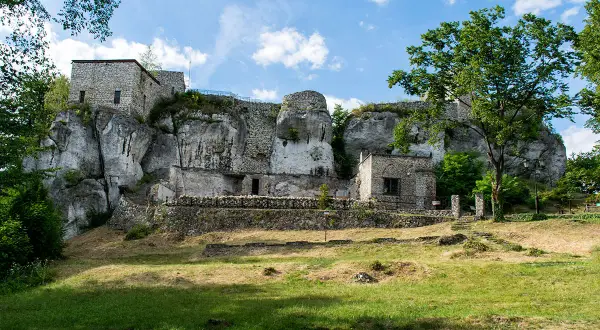 Ruiny zamku na skale, zielona trawa i drzewa. Wspaniałe morsko atrakcje dla miłośników historii i przyrody.