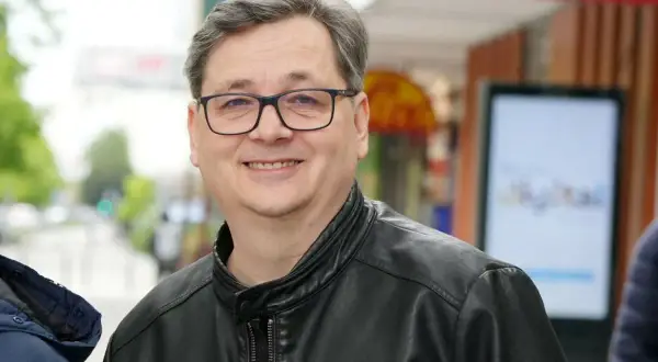 Uśmiechnięty mężczyzna w okularach i skórzanej kurtce. Czy to on wyjaśnia, dlaczego kultowy lektor programu przestał zapowiadać uczestników?