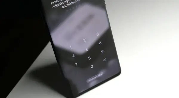 Ekran blokady telefonu z klawiaturą numeryczną i instrukcją "Przeciągnij w górę, aby użyć odblokowywania twarzą lub odciskiem palca". Jak odblokować telefon bez utraty danych?