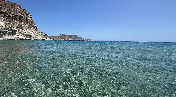 Aguas cristalinas y acantilados blancos en las piscinas naturales de Cabo de Gata. El mar turquesa invita a explorar este paraíso.