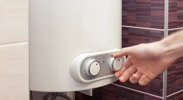 Mano che regola la temperatura di una caldaia a corrente.