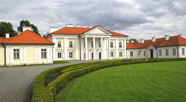 Pałac w Siedlcach, jeden z pięknych zabytków, otoczony zielonym ogrodem i ozdobnymi żywopłotami.