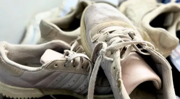 Des baskets beiges un peu usées, prêtes pour un bon nettoyage.