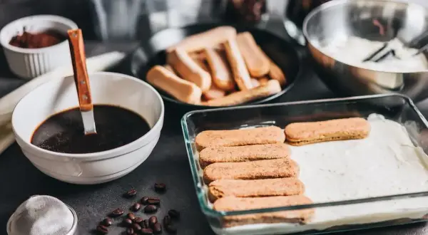 Przygotowanie tiramisu w ciąży: biszkopty maczane w kawie, krem i kakao. Pyszny deser dla przyszłej mamy.