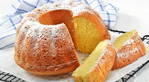 En saftig sockerkaka med sirap istället för socker, pudrad med florsocker. Två skivor ligger bredvid den hela kakan.