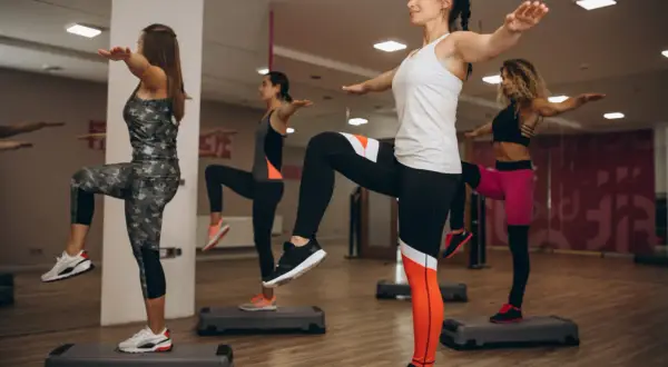 Kobiety ćwiczą na stepach, angażując strefę aerobową.
