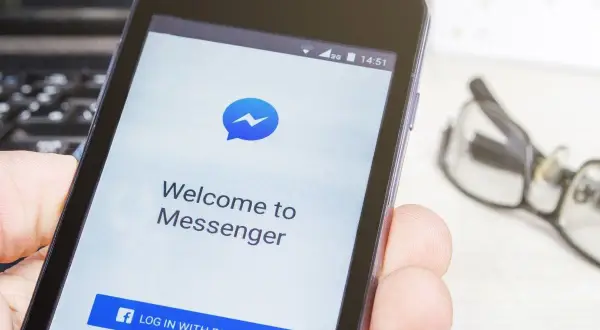 Ekran powitalny Messengera na telefonie, pokazujący jak zainstalować aplikację. Widoczny przycisk "Zaloguj się przez Facebook".