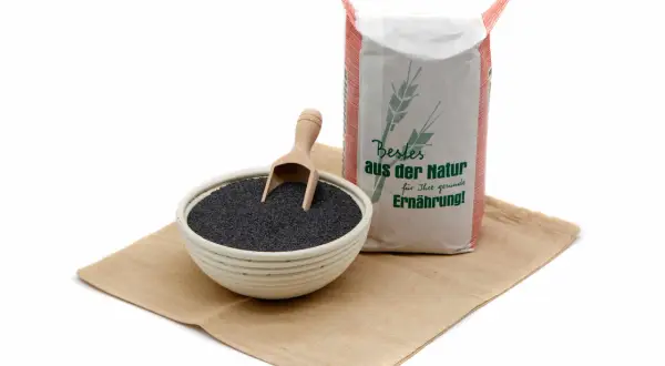 Schale mit Blaumohn und ein Sack "Bestes aus der Natur für Ihre gesunde Ernährung!". Die Blaumohn Wirkung ist vielfältig.
