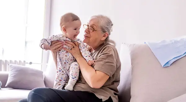 Babcia tuli niemowlę w piżamce z autkami. Czas spędzony w babciowych warunkach to czysta radość.