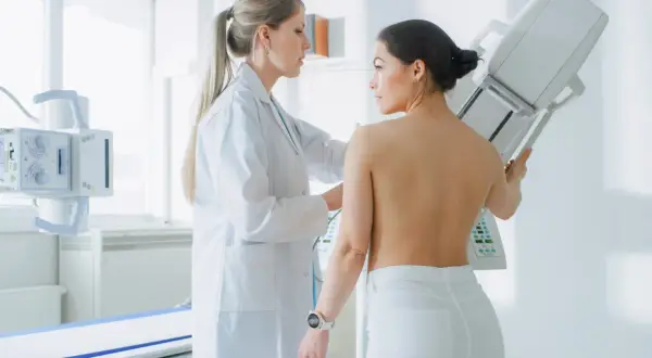 Lekarka wykonuje mammografię pacjentce. Wynik BIRADS 3 oznacza, że zmiany są łagodne, ale wymagają kontroli.