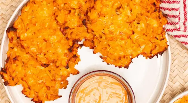 Knusprige Kartoffelpuffer, im Ofen gebacken, serviert mit einer cremigen Dip-Sauce. Perfekt für einen herzhaften Snack.