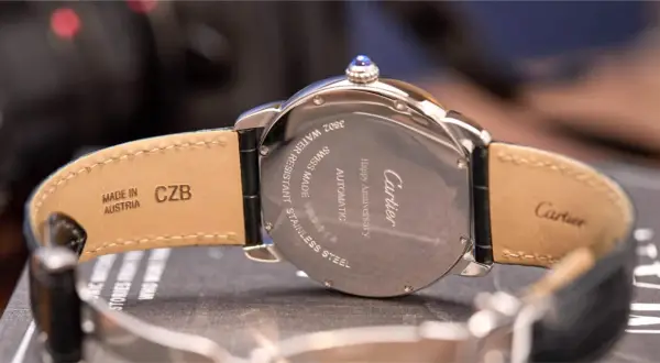 Reloj Cartier con grabado "Happy Anniversary", automático, acero inoxidable, hecho en Suiza. La correa de cuero indica "Made in Austria".