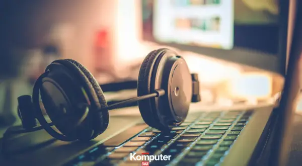 Słuchawki na klawiaturze laptopa, gotowe do zanurzenia się w muzyce na komputerze.