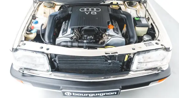 Silnik V8 Audi, potężna jednostka napędowa z lat 90. z widocznymi przewodami i elementami chłodzenia.