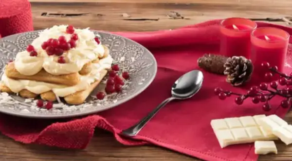 Un délicieux tiramisu chocolat blanc, garni de fruits rouges et de copeaux de chocolat, prêt à être dégusté.