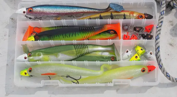 Köderbox mit bunten Gummifischen und Jigs, bereit für das Schleppen auf Hecht.