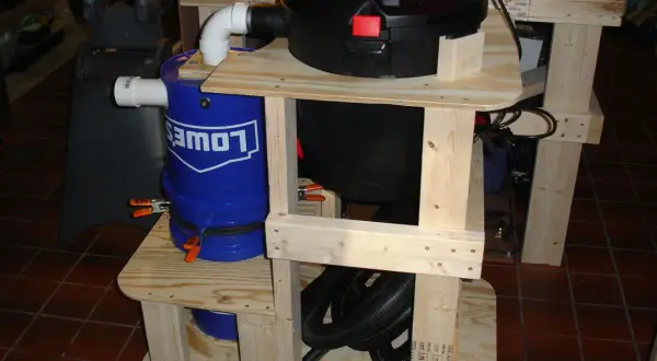 Aspirateur copeaux Leman ASP152 sur un support en bois avec un seau bleu Lowe's.