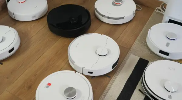 Różne roboty sprzątające na drewnianej podłodze, przygotowane do rankingu.