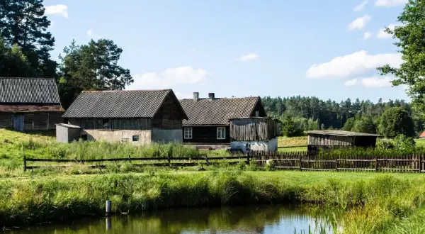 Urokliwe, drewniane domy i stodoły nad spokojnym jeziorem. To obrazek z najpiękniejszych wsi na Mazurach, gdzie czas płynie wolniej.
