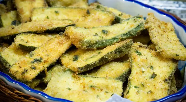 Fettine di zucchine impanate e dorate, pronte per essere gustate. Un contorno sfizioso e leggero, perfetto per ogni occasione.