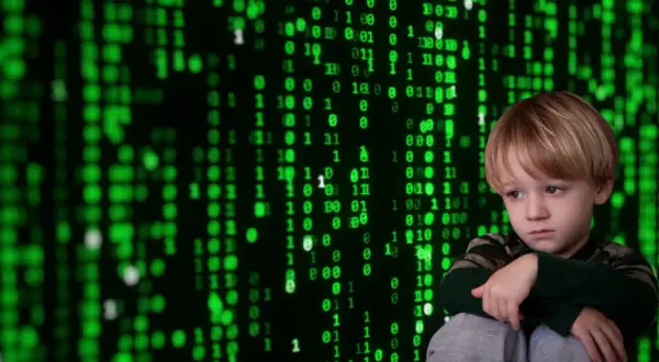 Smutny chłopiec na tle zielonego kodu. Jak zapobiegać cyberprzemocy? Edukacja i wsparcie to klucz do bezpieczeństwa w sieci.
