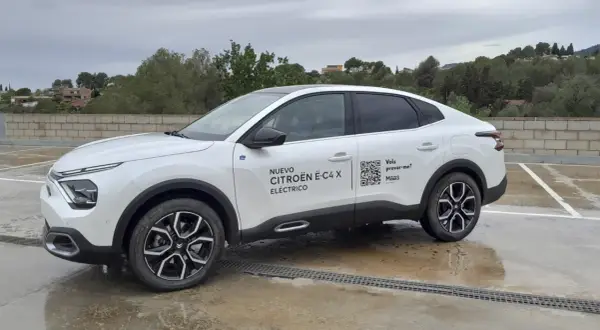 Citroën ë-C4 X eléctrico blanco aparcado en un día nublado. El coche tiene un diseño moderno y elegante.