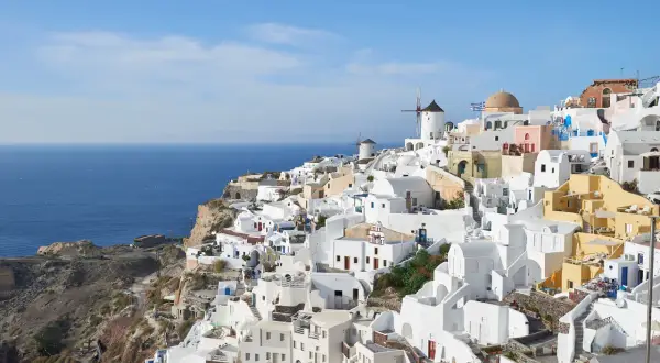 Malownicze białe domy Santorini, wiatraki i błękitne morze. Idealne miejsce na wycieczki z kos.