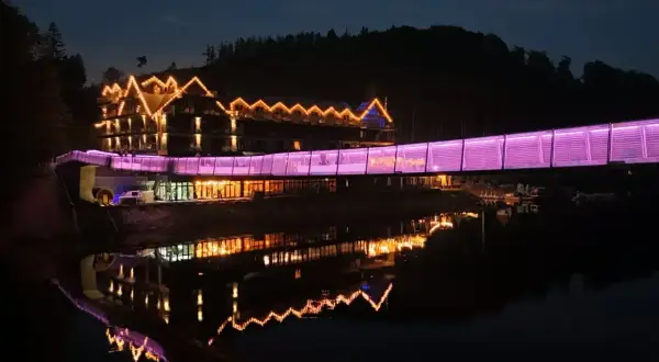 Hotel z mostem oświetlonym na fioletowo, odbijający się w wodzie. Idealne miejsce na weekendowe wypady, jedno z ciekawych miejsc do 100 km od Katowic.