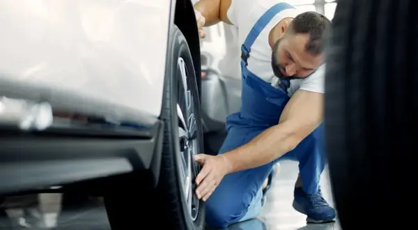 Mekaniker undersöker ett hjul på en VW Amarok, kanske ett vw amarok problem som behöver åtgärdas.