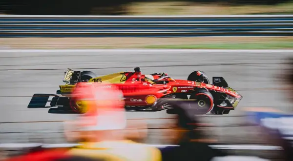 Czerwono-żółty bolid Ferrari z numerem 16 pędzi po torze. Zastanawiasz się, ile trwa wyścig F1? To zależy od wielu czynników, ale zawsze jest to ekscytujące widowisko!