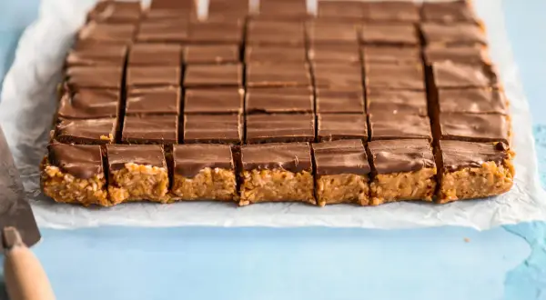 En hel plåt med chokladöverdragna bitar, redo att avnjutas. Ett perfekt snickerskaka recept för fikat.
