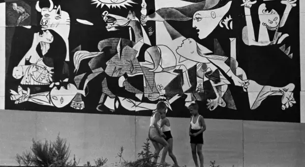 Dzieci bawią się przed monumentalnym obrazem Guernica.