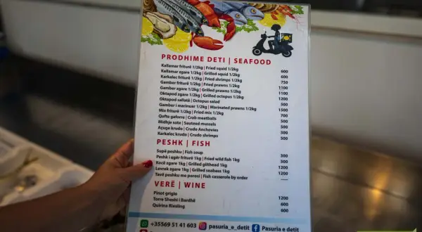 Menu z owocami morza i rybami, część albańskiej kuchni. Widoczne kalmary, krewetki, ośmiornice, ryby i wina.
