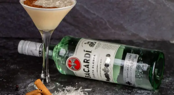 Koktajl z wiórkami kokosowymi i cynamonem, obok butelka Bacardi Carta Blanca. Idealny sposób, jak pić Bacardi!