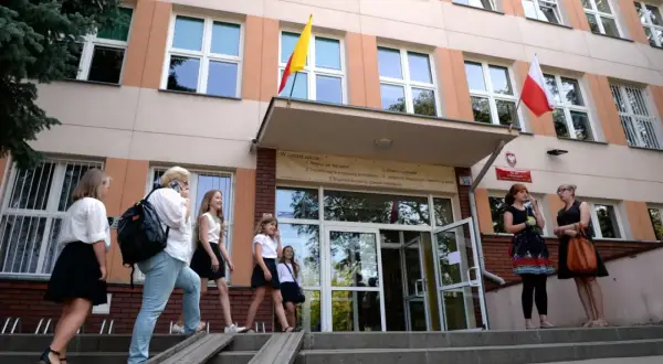 Uczniowie wchodzą do szkoły, przypominając czasy, kiedy powstały gimnazja w Polsce.