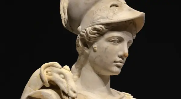 Buste en marbre d'Athéna, déesse guerrière, portant un casque orné d'un serpent. La sculpture, d'une grande finesse, capture la noblesse de la déesse.