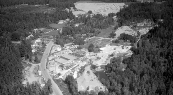Överblicksbild över marmorbruket Kolmården med byggnader, stenbrott och skog.
