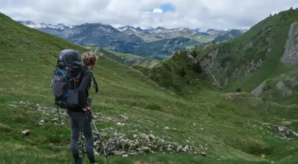 Randonneuse avec un grand sac à dos, prête à explorer les montagnes. Un guide pour comment choisir son sac de randonnée.