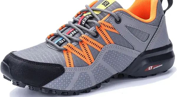 Scarpe da trekking grigie con dettagli arancioni. Il loro significato è comfort e stabilità per ogni avventura.